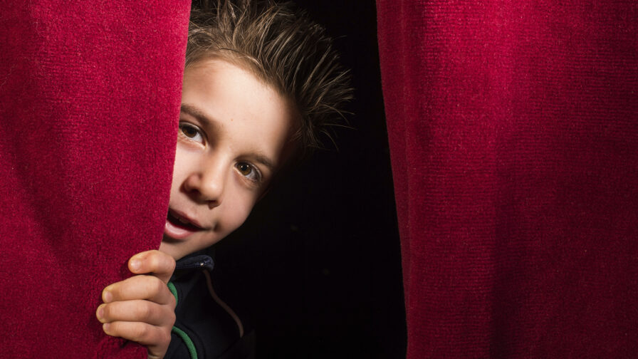 Child appearing beneath the curtain