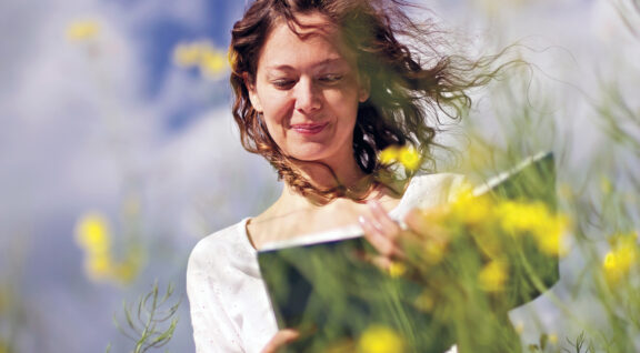 Woman reading in rapeseed field.