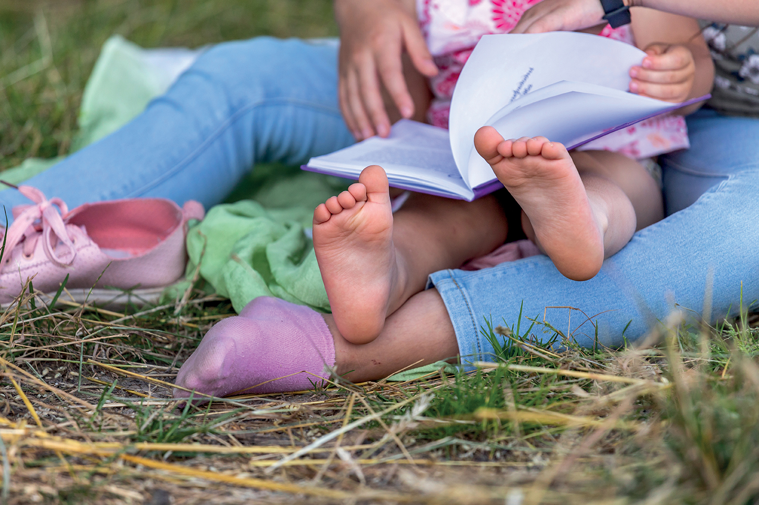 Sisters reading a book in the park