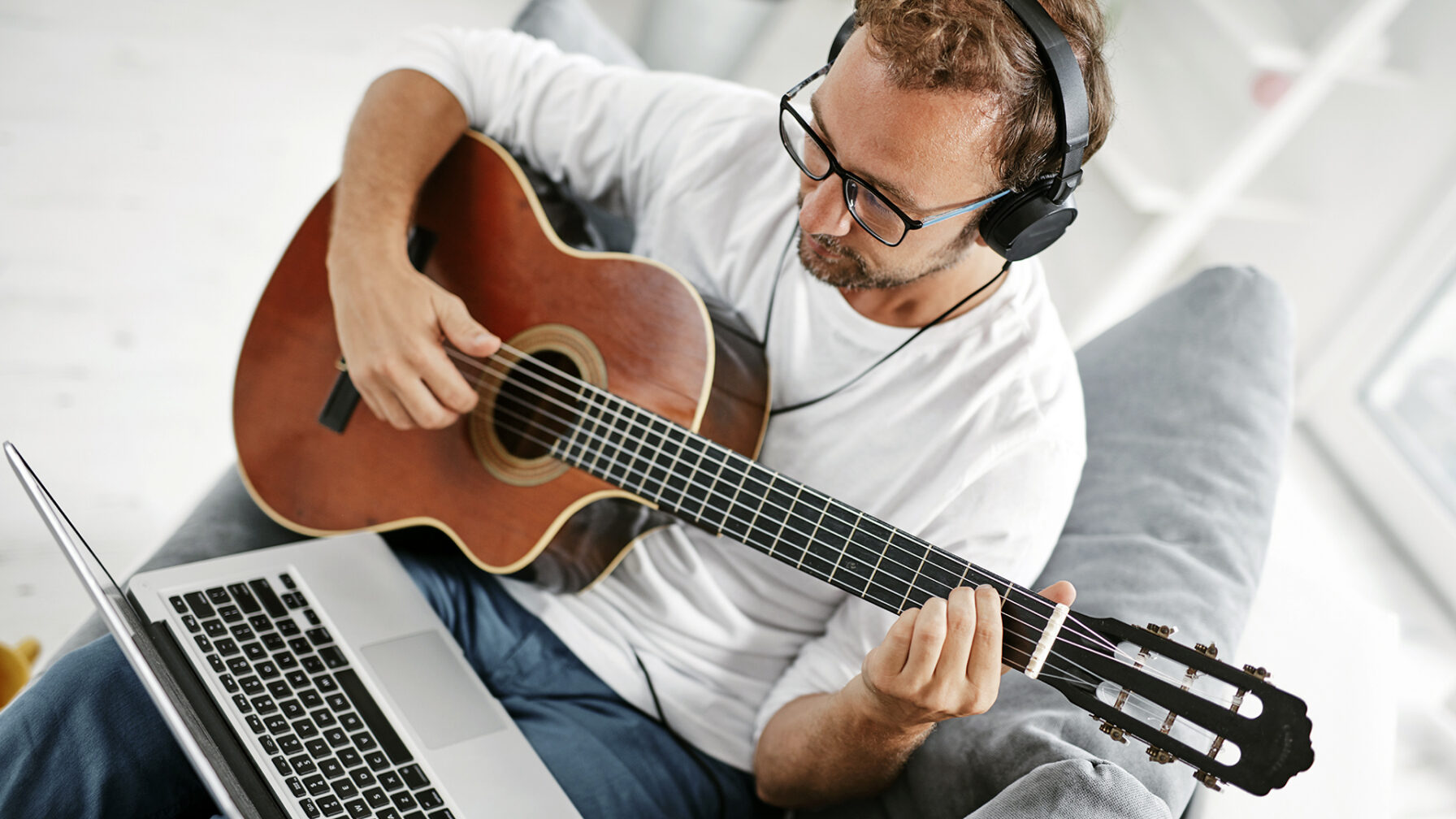 Man playing acoustic guitar in the living room.