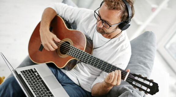 Man playing acoustic guitar in the living room.