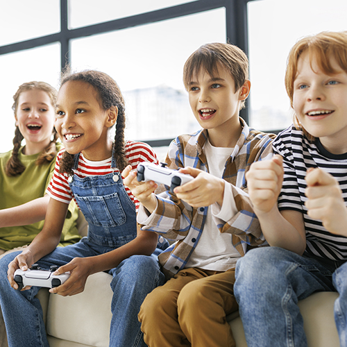 Group of joyful teenage friends with joysticks enthusiastically playing game console
