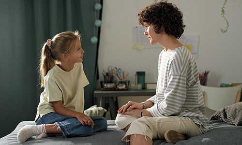 Mother talking to her daughter in bedroom