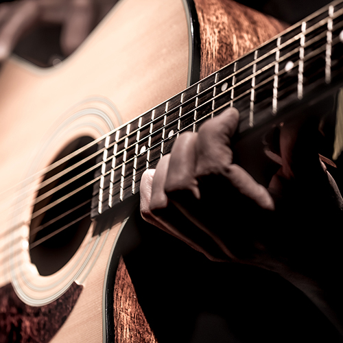 Man playing acoustic guitar on dark background. a musical concept.