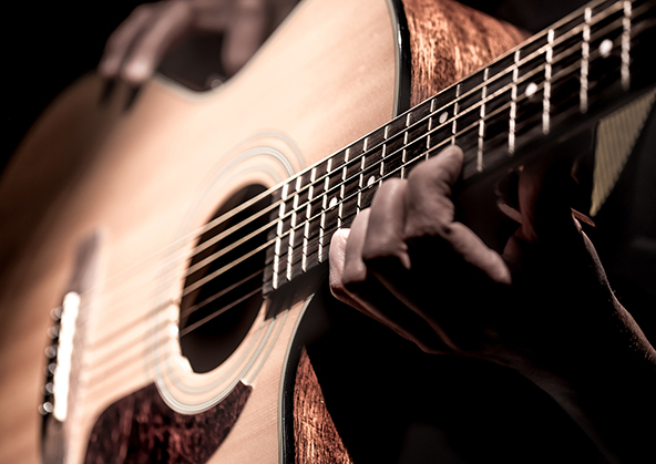 Man playing acoustic guitar on dark background. a musical concept.